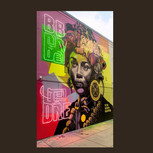Weekly Horoscope – Eclipse Aftermath & Fresh Paths September 7 – September 13, 2025 2 Colorful street mural of a thoughtful woman adorned with flowers and cosmic symbols, surrounded by neon words like ‘BRAVE,’ captured as a visual for the weekly horoscope September 2025 theme.