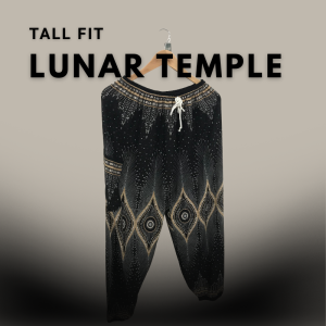 Tall fit black and gold boho harem pants with cosmic design hanging on a wooden hanger, centered on a neutral gradient background.